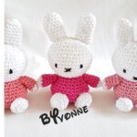 Drie kleine witte handgehaakte konijntjes met rode en roze truien